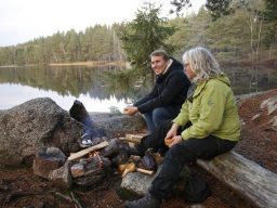 Flera personer vandrar på en stigar i en skog med träd och stenar.