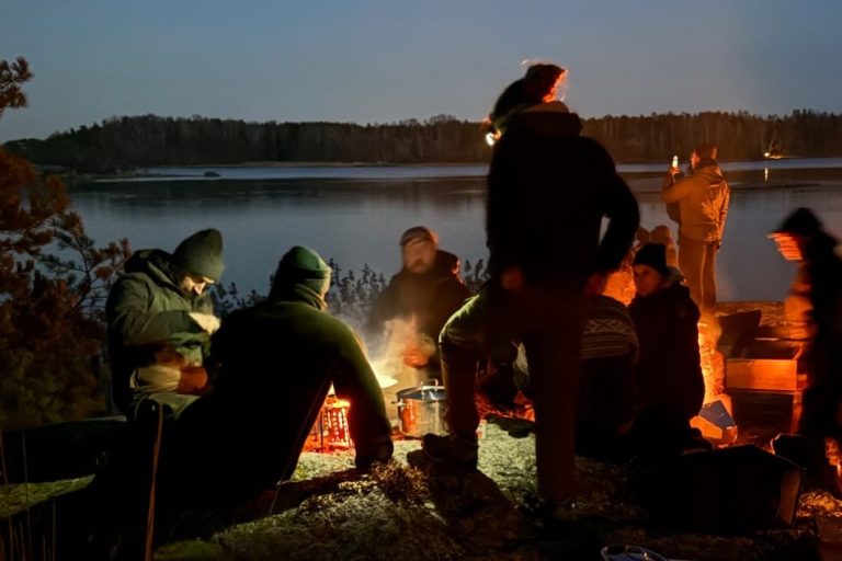 Berättelser från Tiveden runt elden En grupp som sitter runt en lägereld.