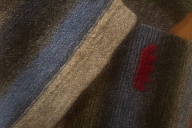 Tre personer i kajaker på en sjö, omgivna av träd och en molnig himmel.